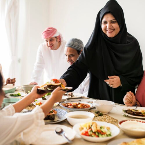 Muslim woman sharing food at Ramadan feast